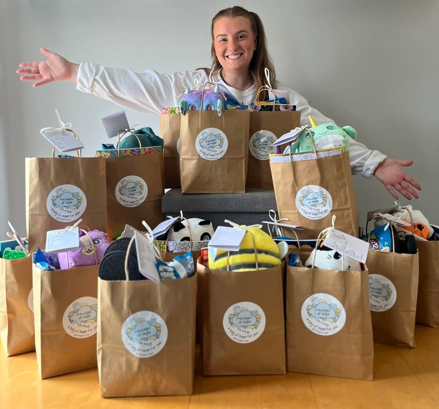 Bethan Evans standing behind a collection of Bags of Hope ready to be delivered