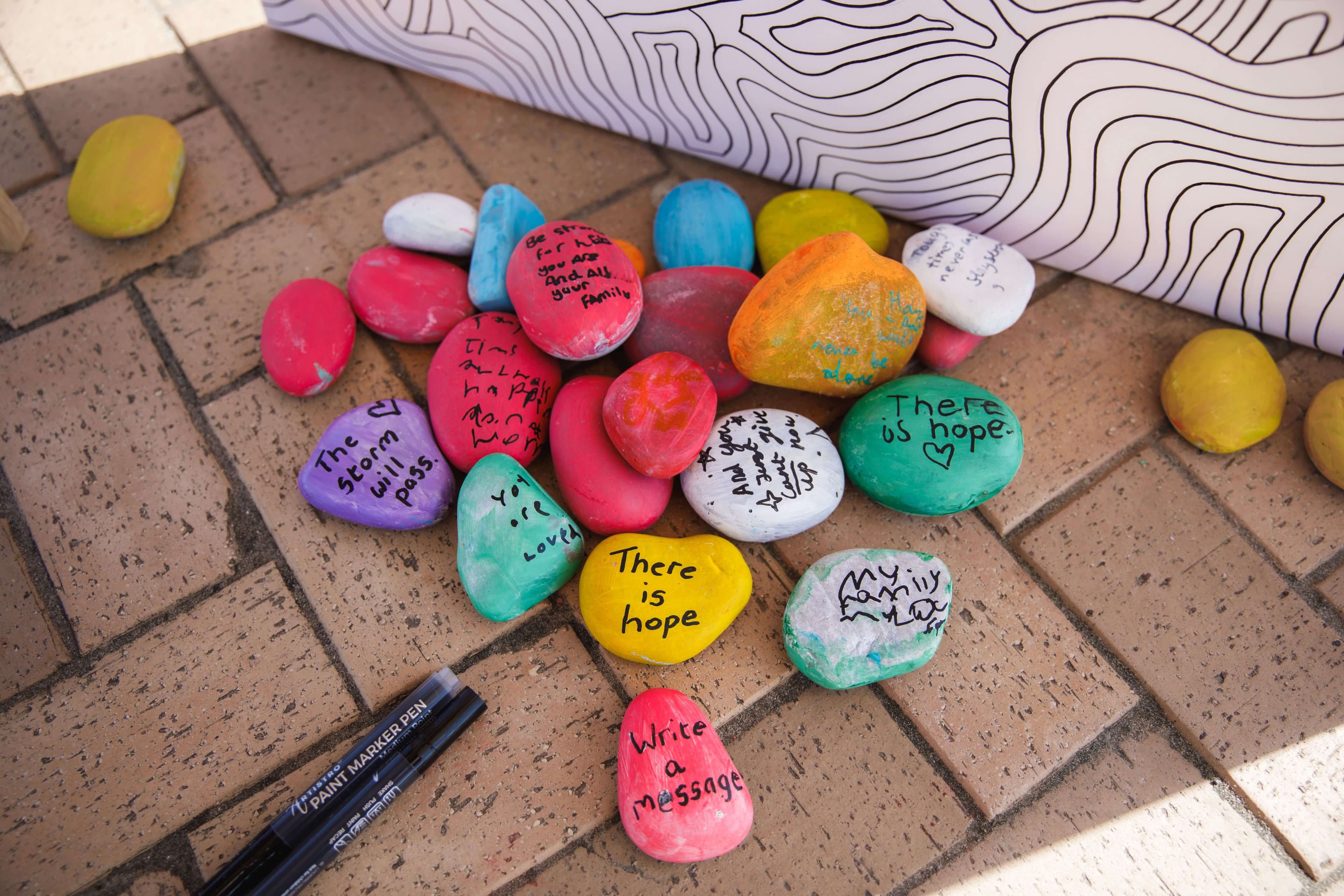 Painted pebbles from Messages of Hope 2023 pop-up art event